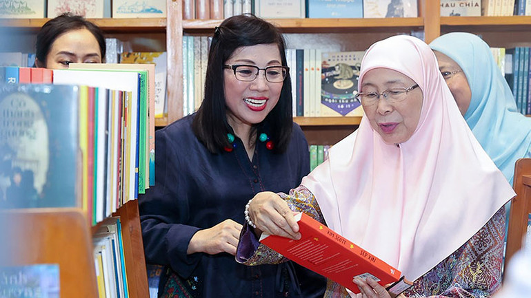 Bà Lê Thị Bích Trân, Phu nhân Thủ tướng Phạm Minh Chính và bà Dato’ Seri Dr. Wan Azizah binti Dr. Wan Ismail, Phu nhân Thủ tướng Anwar Ibrahim xem sách, thích thú khi được trải nghiệm không gian đọc ngoài trời.
