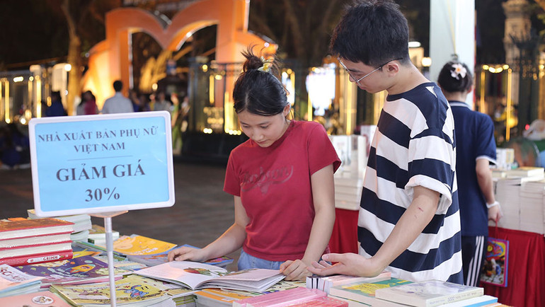 Bạn đọc tìm mua và đọc sách trong buổi tối khai mạc sự kiện.
