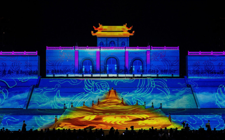 Tà áo dài trải hàng trăm bậc sân khấu.