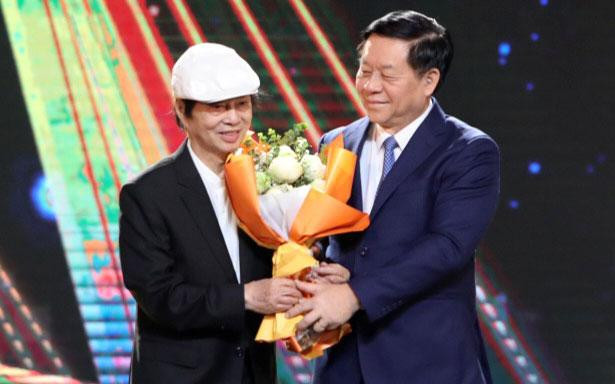 Đồng chí Nguyễn Trọng Nghĩa tặng hoa cho đạo diễn, NSND Đặng Nhật Minh.