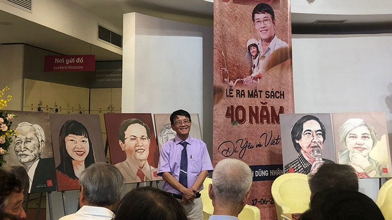 Nhà báo Huỳnh Dũng Nhân và những bức tranh chân dung trưng bày tại buổi ra mắt sách.