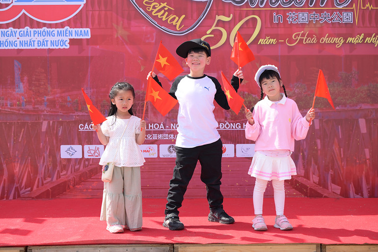 Các em bé hào hứng với lá cờ đỏ sao vàng.