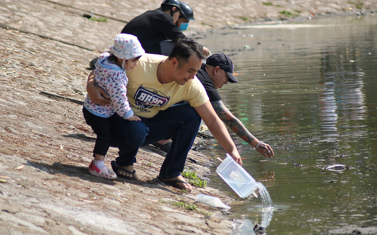 Mang hộp nhựa đi thả cá. (Ảnh: NHẬT QUANG)