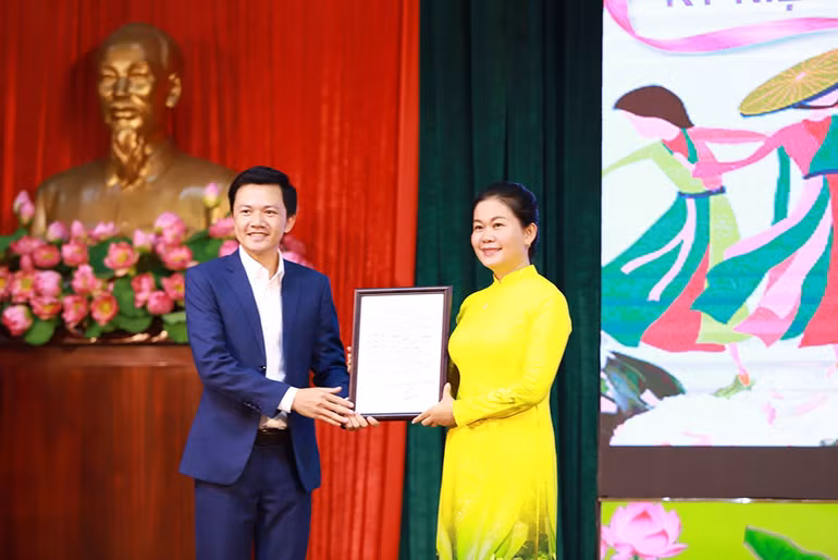 Thay mặt nhà trường, Thượng tá Phạm Thị Mỹ Hạnh, Chủ tịch Hội Phụ nữ nhà trường tiếp nhận bài hát từ nhạc sĩ Nguyễn Bá Hùng.