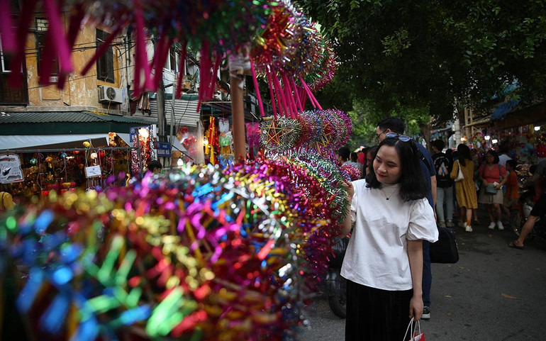 Bạn trẻ Hà Nội chụp ảnh cùng đèn ông sao ở phố Hàng Mã. (ẢNh: THÀNH ĐẠT)