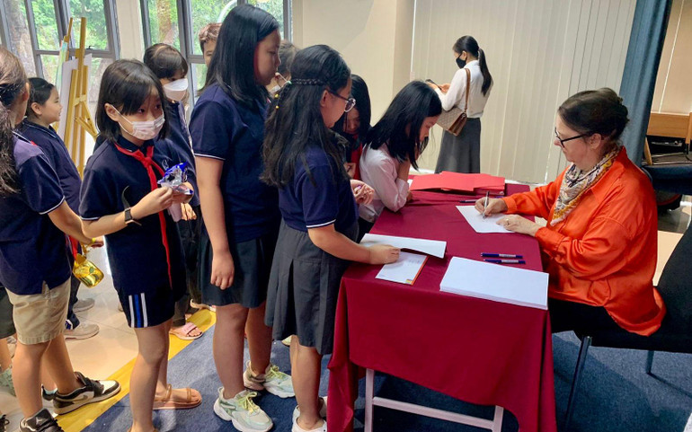 Nữ họa sĩ ký tặng sách cho độc giả.