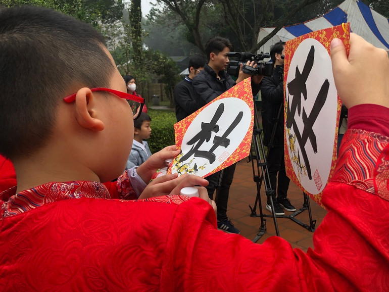 Các bạn nhỏ khoe nhau chữ vừa được thầy đồ viết tặng.