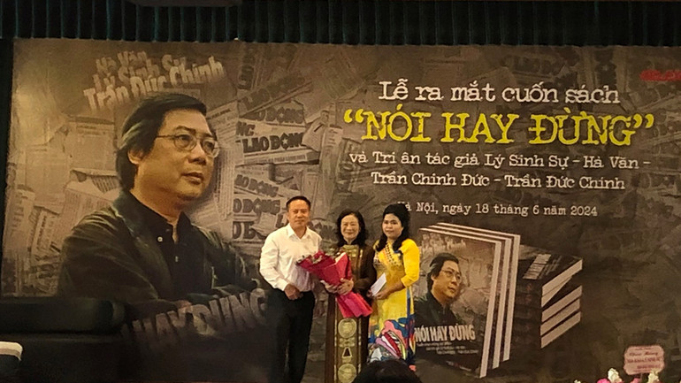 Nhà báo Lưu Quang Định thay mặt nhóm biên soạn tặng hoa cho gia đình nhà báo Trần Đức Chính.