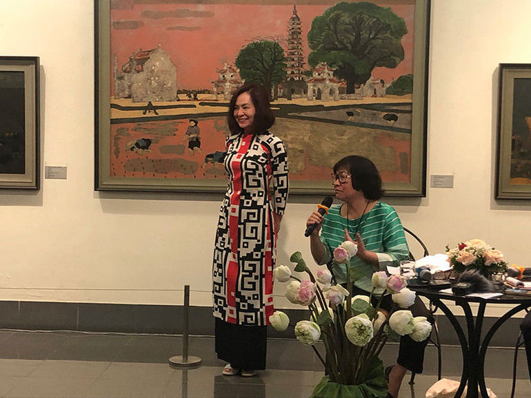 Họa sĩ Đặng Thị Khuê giới thiệu chiếc áo dài 40 năm trước tại triển lãm cá nhân của họa sĩ Nguyễn Sáng, nay được con gái bà mặc lại.