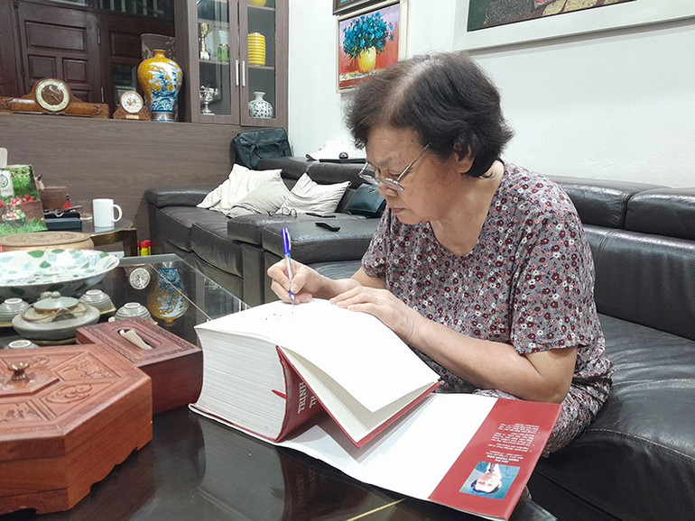 Bà Mai Thị Lý bên tập di cảo của nhà thơ Trịnh Thanh Sơn.