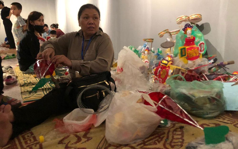 Nghệ nhân Nguyễn Thị Tuyết đang phất giấy bóng kính cho một chiếc đèn cá trong sự kiện Trung thu tại Bảo tàng Dân tộc học Việt Nam.