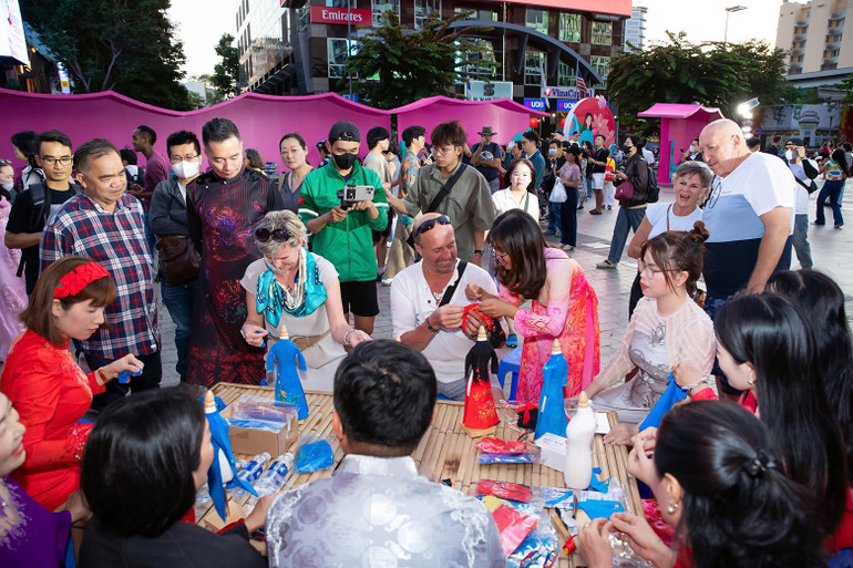 Nhà thiết kế Đỗ Trịnh Hoài Nam (mặc áo dài, đứng) tại workshop dành cho du khách tìm hiểu về áo dài.