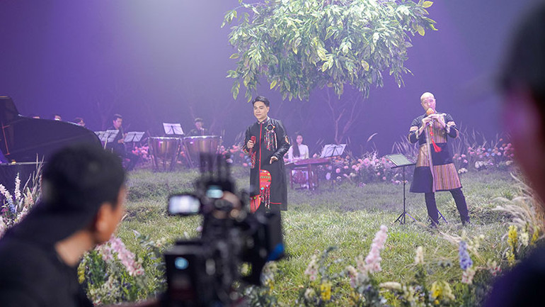 Nhạc trưởng Đồng Quang Vinh (bên phải) trong MV của Tùng Anh.