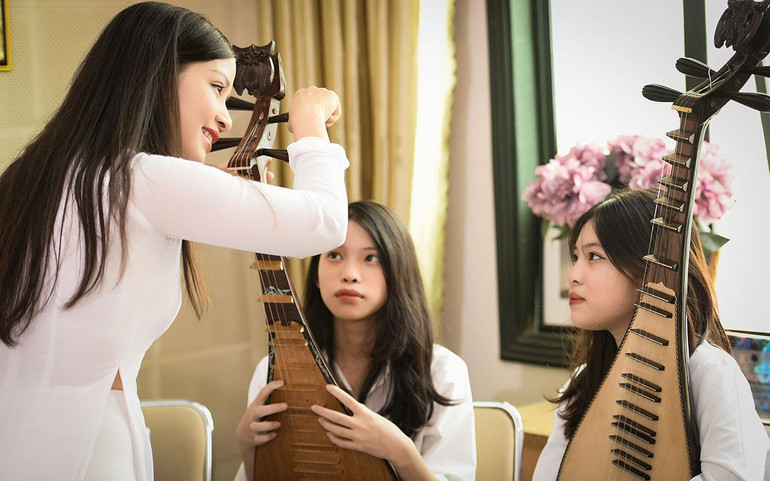 Cô Diệu Thảo hướng dẫn các học sinh chỉnh đàn. Cô Diệu Thảo hướng dẫn các học sinh chỉnh đàn.