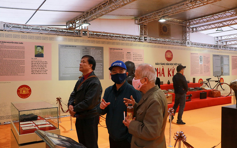 Khách tham quan tìm hiểu các tư liệu, hiện vật về các nhà văn, nhà thơ. (Ảnh: NHẬT QUANG)
