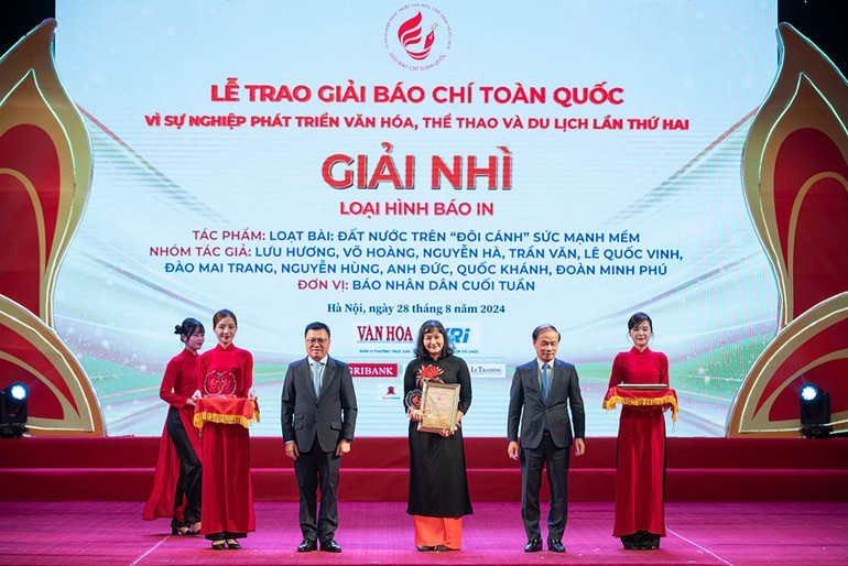 Đại diện nhóm tác giả của Báo Nhân Dân cuối tuần nhận giải Nhì loại hình báo in.