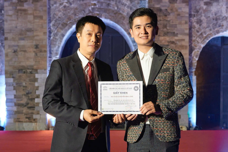 Nhà thiết kế Nguyễn Minh Long nhận giấy khen từ Liên hiệp các hội UNESCO Việt Nam. Nhà thiết kế Nguyễn Minh Long nhận giấy khen từ Liên hiệp các hội UNESCO Việt Nam.