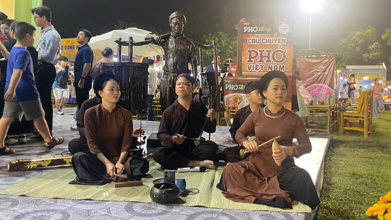 Trình diễn xẩm bên bức tượng Phở gánh.