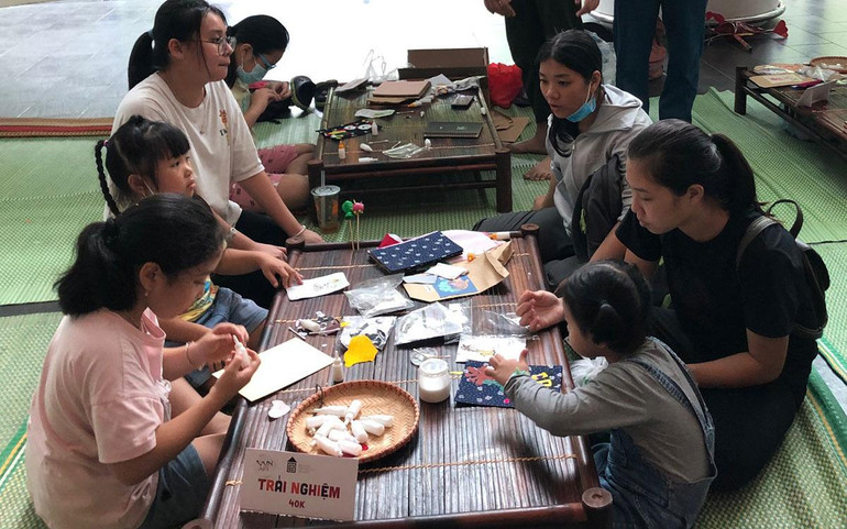 Các em nhỏ dán tranh vải bằng nguyên liệu tái chế. Các em nhỏ dán tranh vải bằng nguyên liệu tái chế.