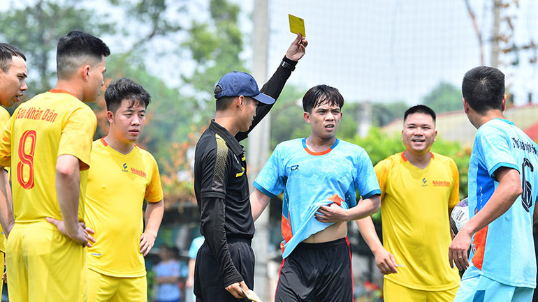 Trọng tài rút thẻ vàng cảnh cáo cầu thủ bên phía Bộ Thông tin và Truyền thông.