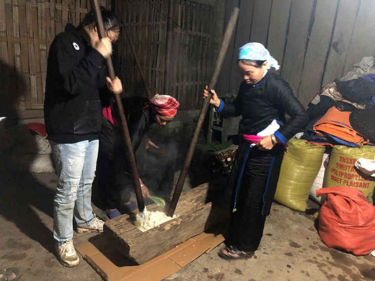 Vừa giã vừa đảo xôi trong cối. Vừa giã vừa đảo xôi trong cối.