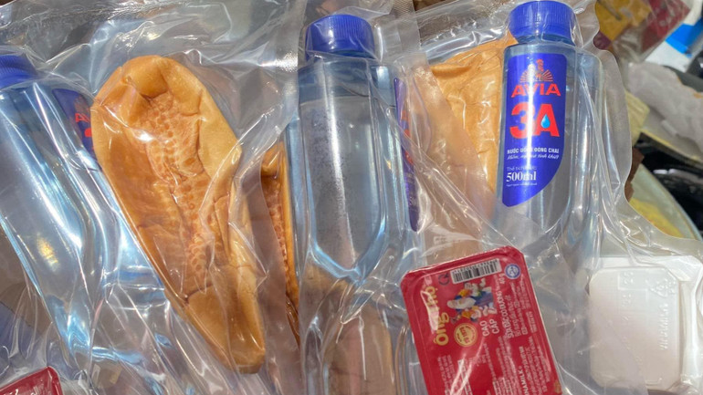 Nước lọc, bánh mỳ và sữa được người dân huyện Tân Uyên đóng thành từng gói để gửi bà con vùng thiên tai Lào Cai, Yên Bái.