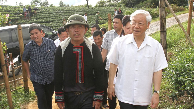 Ông Hạng A Sào giới thiệu với Tổng Bí thư Nguyễn Phú Trọng và hướng dẫn đoàn tham quan đồi chè của bản.