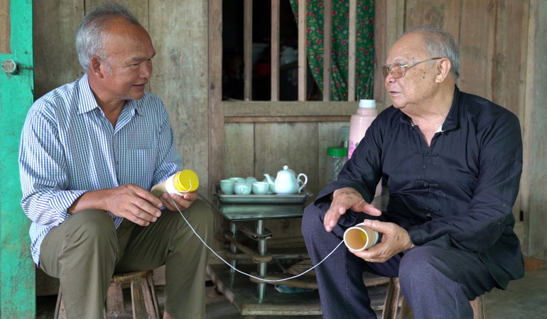 Hằng ngày ông Chiến (áo đen bên phải) vẫn về bản của người Pú Nả để tìm tư liệu, nghiên cứu văn hóa.