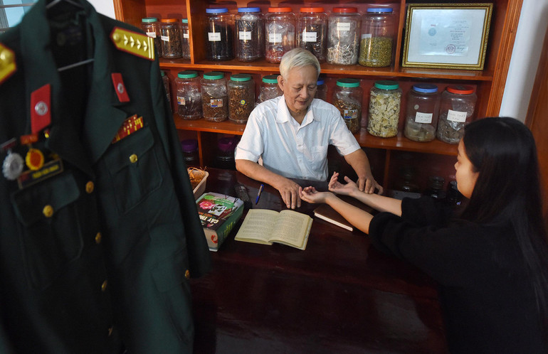 Rất nhiều bệnh nhân vượt hàng trăm km tìm đến với ông để chữa trị, không chỉ vì thuốc hay, hiệu nghiệm mà còn vì sự đức độ, nhân hậu của ông. Trong ảnh: Thầy thuốc Trần Văn Nhân đang khám cho bệnh nhân đến từ Lệ Thủy, tỉnh Quảng Bình.