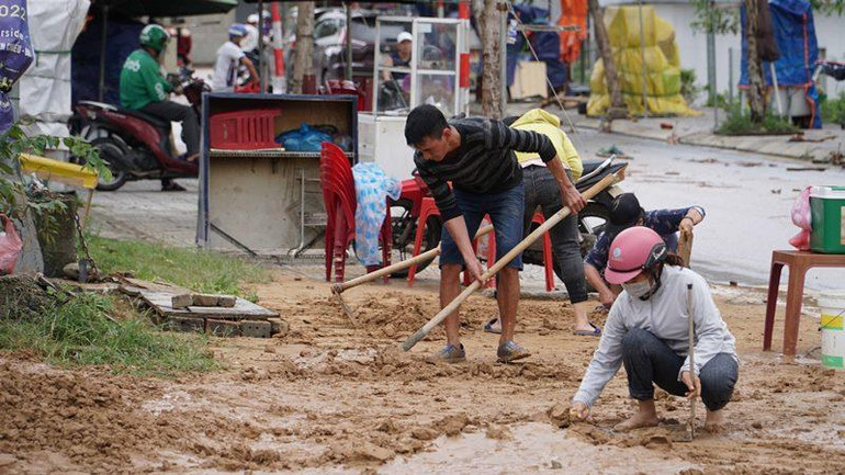 Người dân lấy nước về dọn bùn đất.