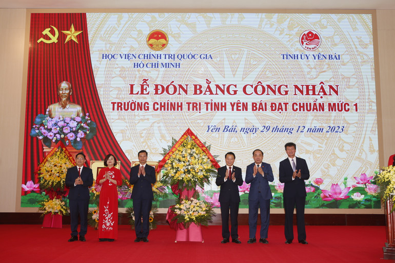 Lãnh đạo tỉnh Yên Bái tặng hoa chúc mừng nhà trường. (Ảnh: THANH SƠN)