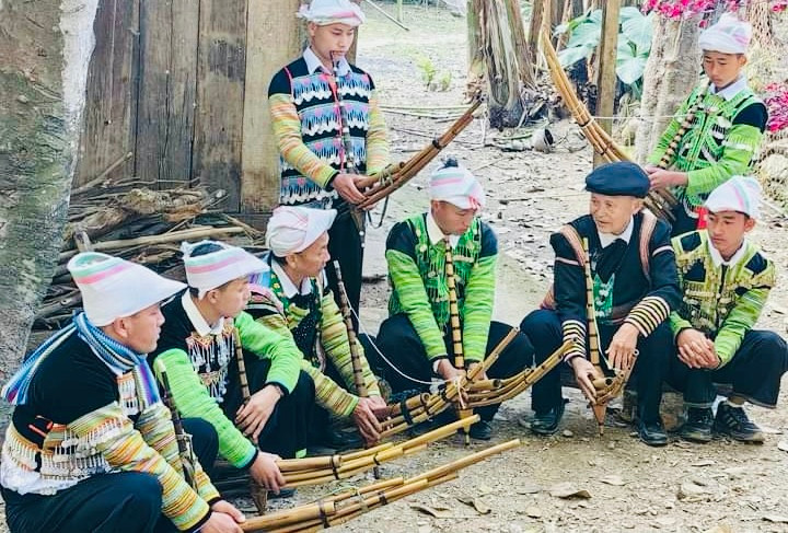 Nghệ nhân Giàng A Su, huyện Trạm Tấu (người mặc áo đen) giới thiệu khèn Mông cho lớp trẻ. (Ảnh THANH SƠN)