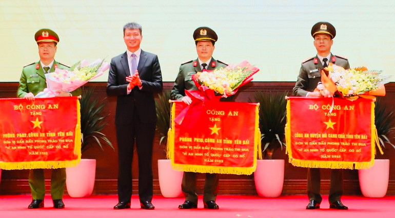 Chủ tịch Ủy ban nhân dân tỉnh Yên Bái trao cờ thi đua cho các đơn vị. (Ảnh: THANH SƠN)