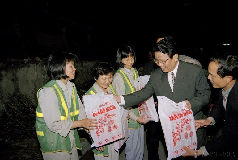 Chủ tịch nước Trần Đức Lương tặng quà và chúc Tết công nhân tổ 10 (Công ty Môi trường và Đô thị Hà Nội) đang làm nhiệm vụ trong đêm giao thừa Tết Kỷ Mão (1999). Ảnh: TTXVN