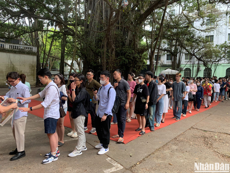 Xếp hàng dài chờ tặng báo Nhân Dân có phụ trương in tranh panorama "Chiến dịch Điện Biên Phủ".