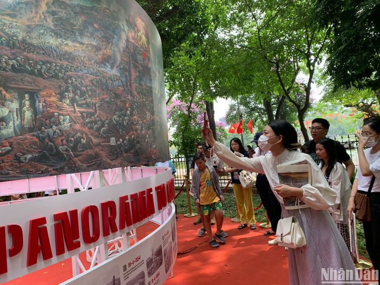 Độc giả hào hứng quét mã QR trên tranh panorama.