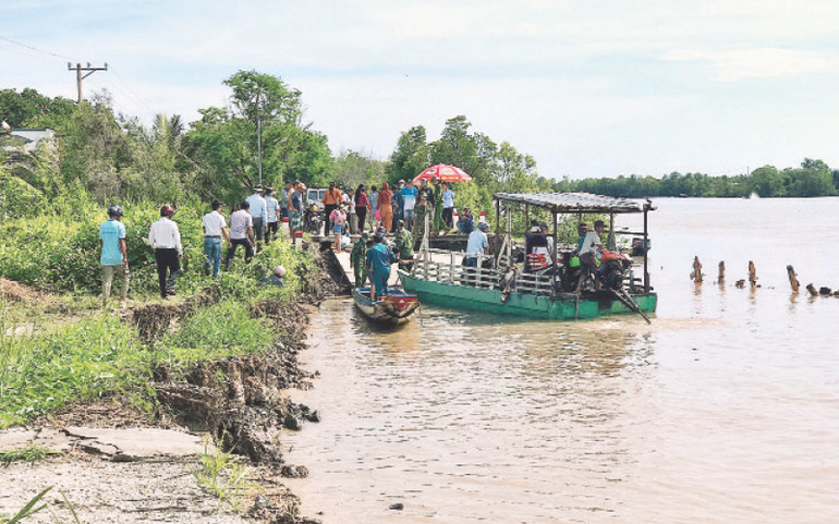 Chính quyền huyện Đầm Dơi huy động phà giúp người dân ra khỏi khu vực sạt lở ở xã Nguyễn Huân.