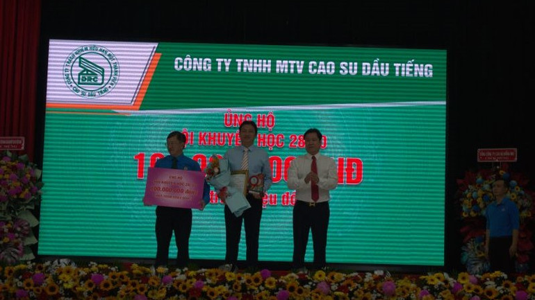 Ông Nguyễn Đức Hiền (ở giữa), Tổng Giám đốc Công ty TNHH MTV Cao-su Dầu Tiếng trao đóng góp Quỹ Khuyến học 28/10.