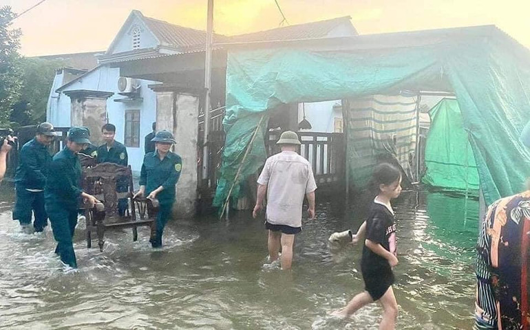 Dân quân huyện Yên Bình giúp dân di chuyển vật dụng gia đình chạy lũ.(Ảnh:THANH SƠN)