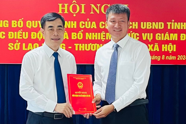 Chủ tịch Ủy ban nhân dân tỉnh Trần Huy Tuấn (bên phải) trao quyết định Giám đốc Sở Lao động-Thương binh và xã hội đối với đồng chí Đỗ Quang Minh. (Ảnh: THANH SƠN)