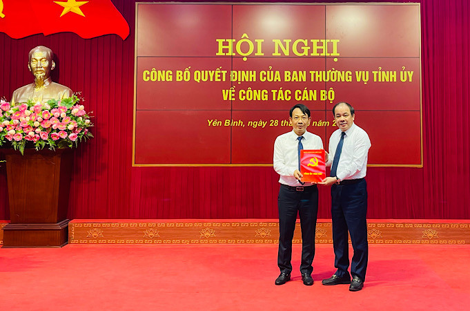 Đồng chí Tạ Văn Long, Phó Bí thư Thường trực Tỉnh ủy trao Quyết định bổ nhiệm Bí thư Huyện ủy Yên Bình đối với đồng chí Đỗ Văn Nghị. (Ảnh: THANH SƠN)