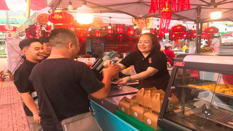 Khách mua món ăn tại một gian hàng trong lễ hội