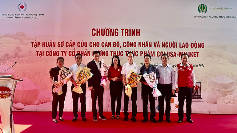 Đồng chí Bùi Thị Hòa, Bí thư Đảng đoàn, Chủ tịch Trung ương Hội Chữ thập đỏ Việt Nam tặng hoa cho các thành viên tham gia lớp tập huấn