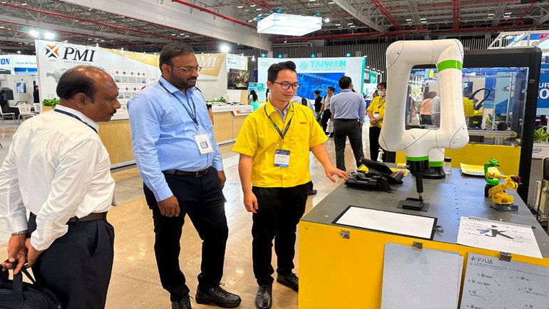 Khách tham quan một hệ thống máy gia công cơ khí chính xác tại triển lãm.