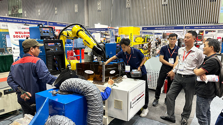 Khách tham quan tìm hiểu máy móc, thiết bị, công nghệ mới tại một gian hàng trong triển lãm