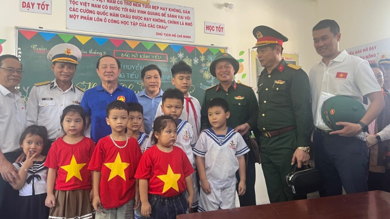 Phó Trưởng Ban Tuyên giáo và Dân vận Trung ương Huỳnh Thành Đạt (áo thun xanh) và lãnh đạo các đoàn công tác Văn phòng Chính phủ, tỉnh Hòa Bình, tỉnh Lào Cai, Quân chủng Hải quân thăm thầy trò trên đảo Sinh Tồn.