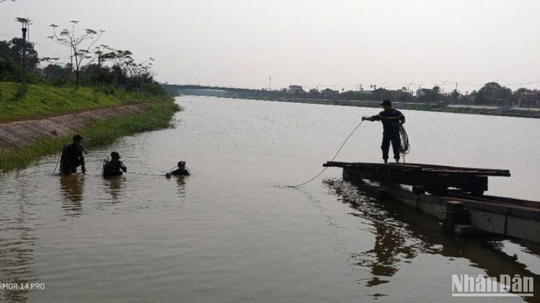 Lực lượng chức năng tìm kiếm thi thể học sinh bị đuối nước tại khu vực đập ngăn mặn, thành phố Đông Hà.