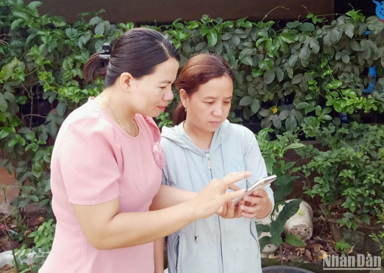 Chủ tịch Hội nông dân thị trấn Krông Klang, huyện Đakông (bên trái) kiểm tra kết quả trả nợ vốn vay của hội viên qua phần mềm quản lý tín dụng chính sách.