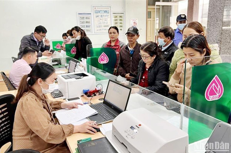 Khách hàng được cán bộ Phòng Giao dịch ngân hàng chính sách xã hội huyện Hướng Hóa hỗ trợ cài đặt ứng dụng VBSP Smart Banking.