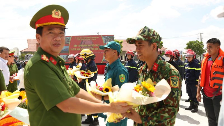 Đại tá Nguyễn Thanh Điệp, Phó Giám đốc Công an tỉnh Bình Dương và đại diện các ban, ngành của tỉnh trao tặng hoa chúc mừng các lực lượng phối hợp thực hiện buổi diễn tập.